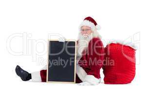 Santa sits leaned on his bag with a board