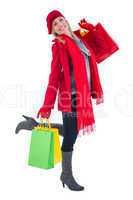 Happy blonde in winter clothes holding shopping bags