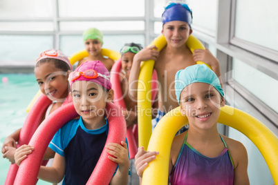 Cute swimming class smiling poolside