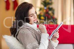 Brunette lying on the couch thinking about her christmas list