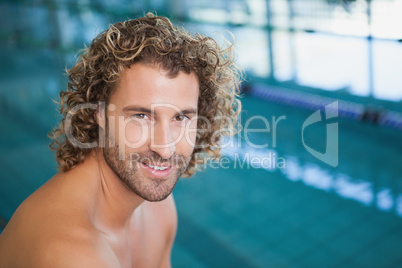 Close up portrait of a shirtless fit swimmer by pool