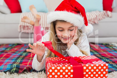 Festive little girl opening a gift