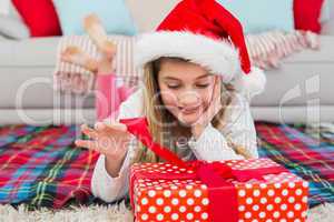 Festive little girl opening a gift
