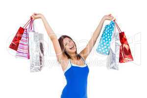 Excited young woman holding up shopping bags
