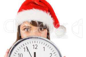 Portrait of a festive brunette holding a clock