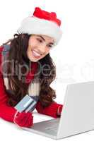 Smiling brunette shopping online with laptop