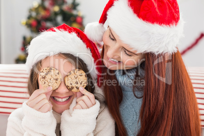 Festive mother and daughter on the couch with cookies