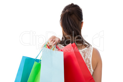 Rear view of brunette holding shopping bags