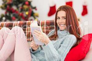 Festive redhead reading on the couch