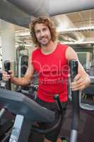 Handsome man working out on x-trainer in gym