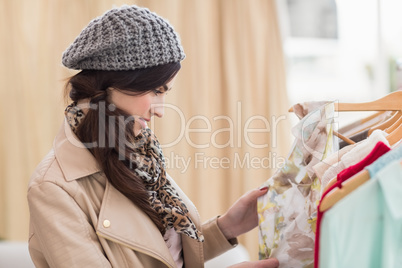 Pretty shopping brunette looking at dress