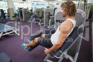 Side view of man doing leg workout at gym