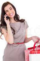 Smiling brunette with shopping bags on the phone
