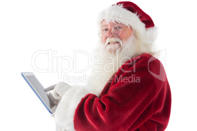 Santa uses a tablet PC and smiles into the camera