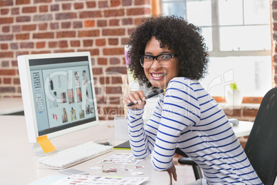 Smiling female photo editor at office desk