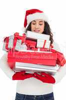 Stressed brunette in santa hat holding pile of gifts