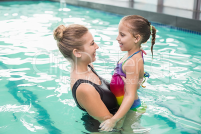 Cute little girl learning to swim with mum