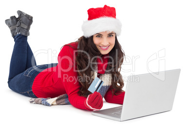 Festive brunette shopping online with laptop Festive brunette shopping online with laptop