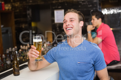 Young man holding pint of beer