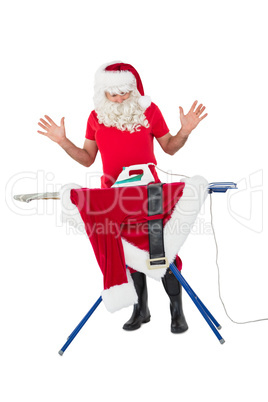 Surprised santa claus ironing his jacket