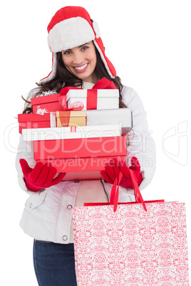 Brunette in winter clothes holding many gifts and shopping bags