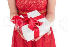 Pretty woman in red dress offering present
