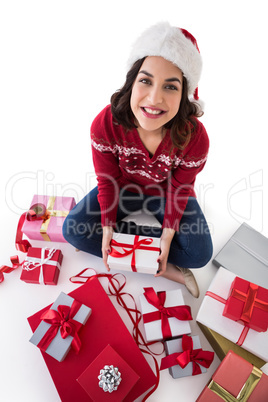 Happy brunette sitting and wrapping christmas presents