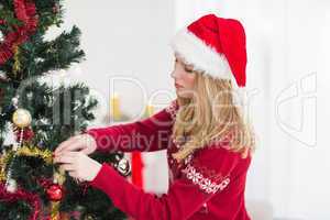 Young woman decorating a Christmas tree