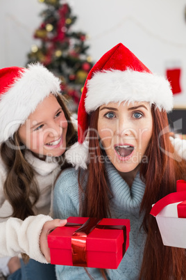 Festive mother and daughter exchanging gifts