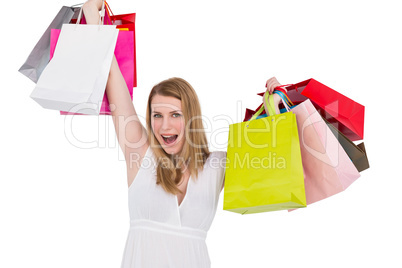 Blonde woman raising shopping bags