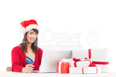 Festive brunette shopping online with laptop