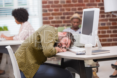 Casual man resting head on computer keyboard