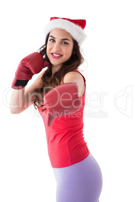 Festive brunette in boxing gloves punching