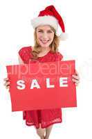 Pretty blonde in santa hat holding a red sale poster