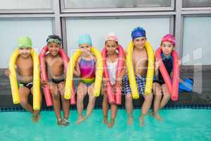 Cute swimming class smiling poolside