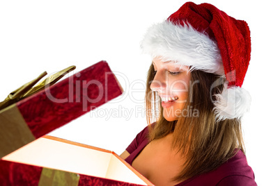 Pretty brunette in santa hat opening a gift