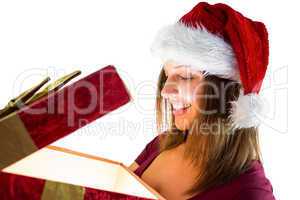 Pretty brunette in santa hat opening a gift