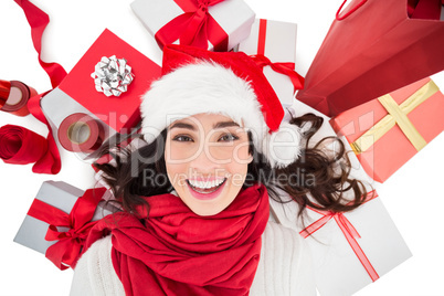 Festive brunette lying near christmas presents