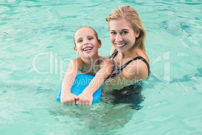 Happy mother and daughter in the swimming pool