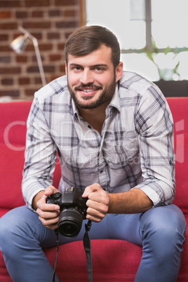 Portrait of casual photo editor holding camera