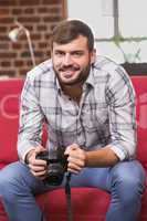 Portrait of casual photo editor holding camera