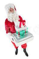 Happy santa claus holding pile of gifts