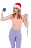 Smiling fit blonde holding dumbbell and measuring tape