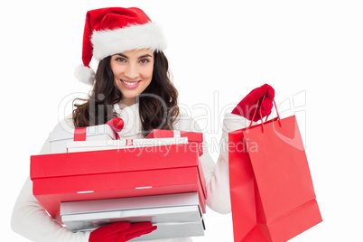 Festive brunette holding christmas gifts and shopping bags