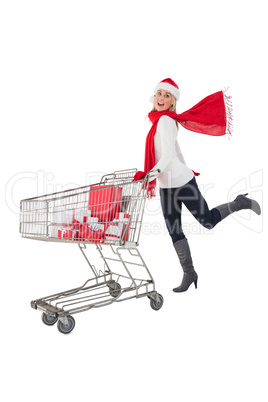 Festive blonde pushing trolley full of gifts