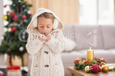 Festive little girl blowing over hands