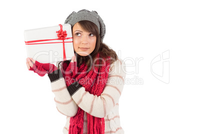 Festive brunette holding white and red gift