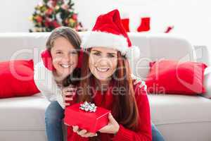 Festive mother and daughter with a christmas gift