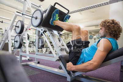 Handsome man doing leg presses in gym