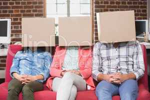 Team sitting on couch with boxes over heads